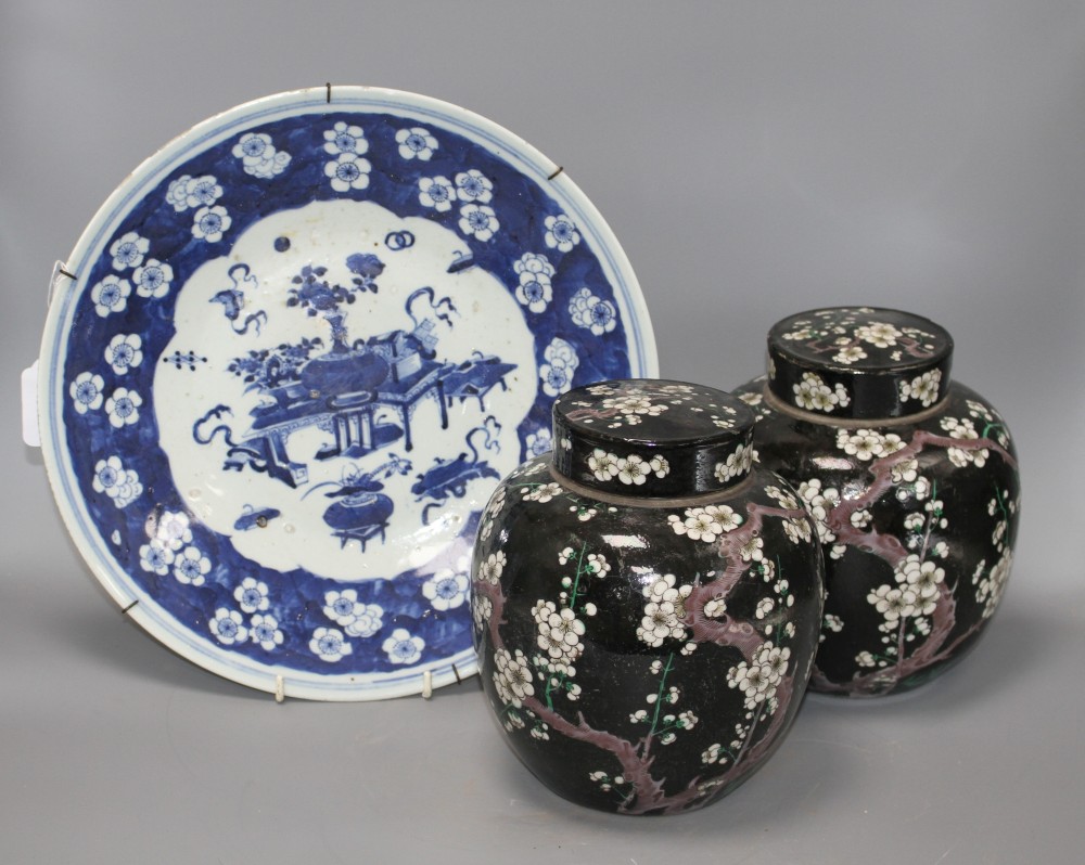 A pair of Chinese famille noire ginger jars and covers, decorated with prunus, height 20cm, and a blue and white dish, 34cm